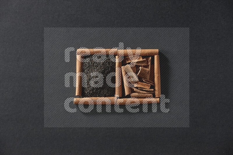 مربعان من أعواد القرفة ممتلئان بالشاي والقرفة علي خلفية سوداء