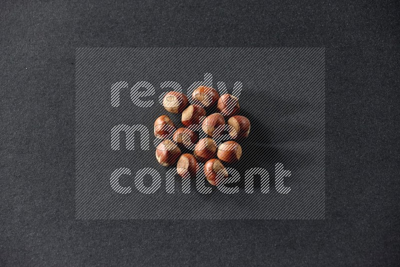 A bunch of hazelnuts on a black background in different angles