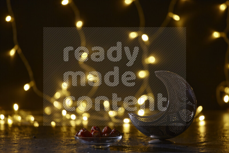 A traditional ramadan lantern surrounded by glowing fairy lights in a dark setup