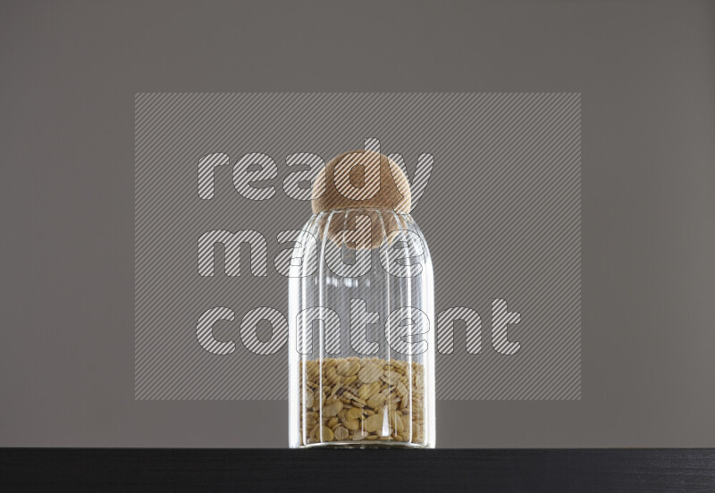 Crushed beans in a glass jar on black background