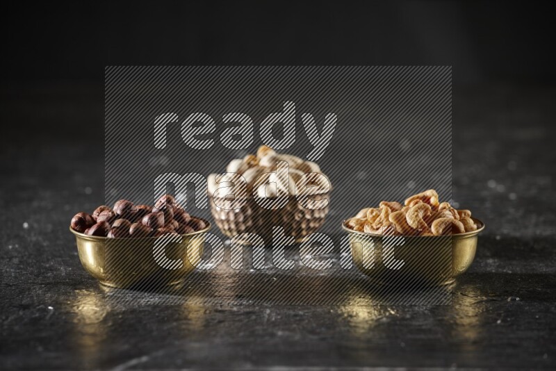 Nuts in a metal bowl in a dark setup