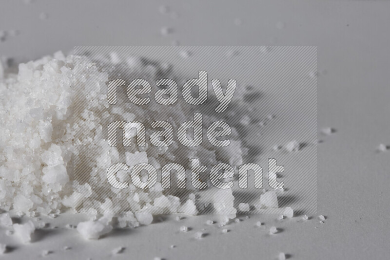 A bunch of coarse sea salt crystals on white background