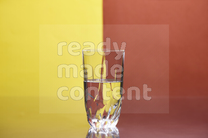 The image features a clear glassware filled with water, set against yellow and dark orange background