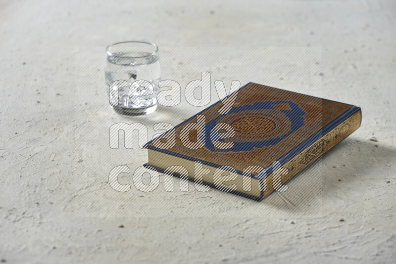 Quran with dates, prayer beads and different drinks all placed on textured white background