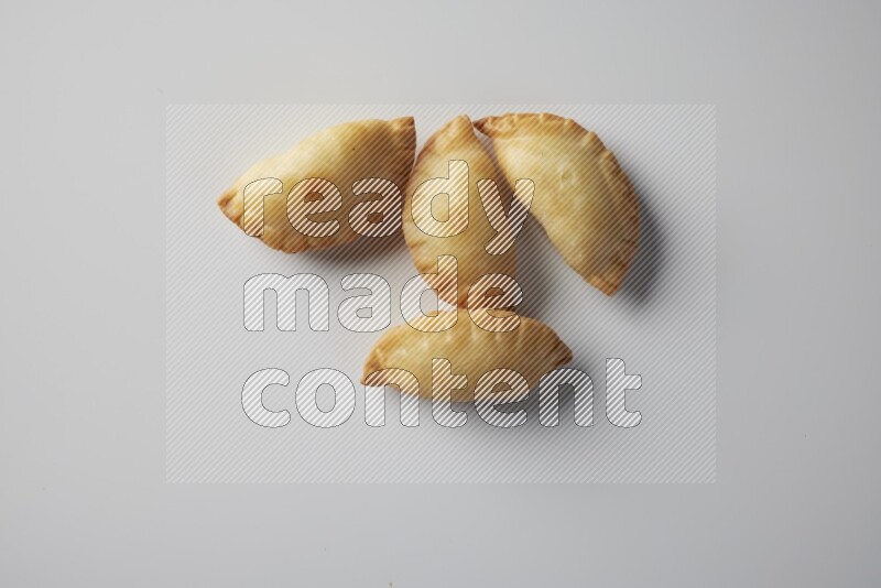 Four fried sambosa from a top angle on a white background
