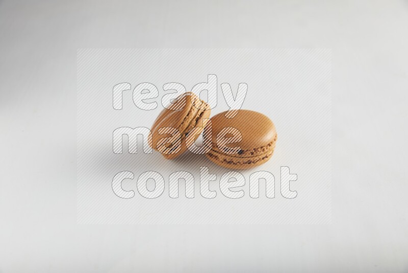 45º Shot of of two assorted Brown Irish Cream, and Brown Maple Taffy macarons  on white background