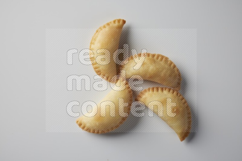 Four fried sambosa from a top angle on a white background