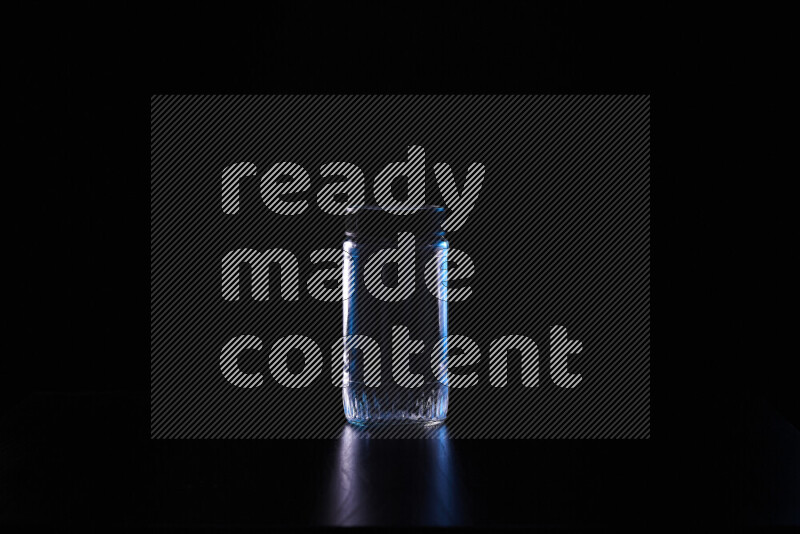 Glassware with rim light in blue and white against black background