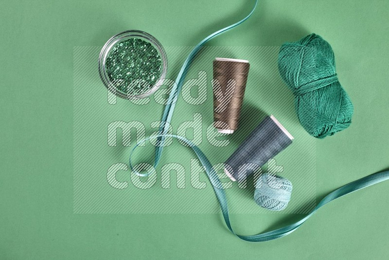 Green sewing supplies on green background