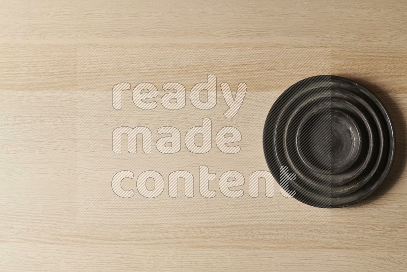 Top View Shot Of A Pottery Ripple Black Plate on Oak Wooden Flooring