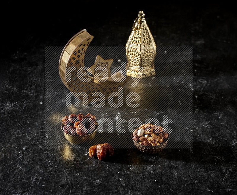 Dates in a metal bowl with mixed nuts beside golden lanterns in a dark setup