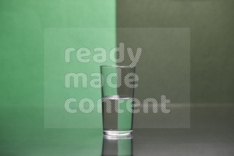 The image features a clear glassware filled with water, set against green and dark green background