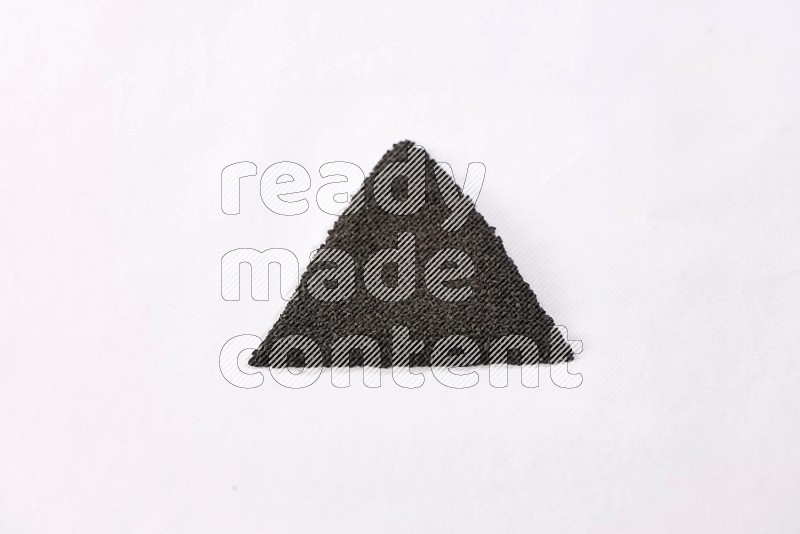Black seeds in a triangle shape on a white flooring in different angles