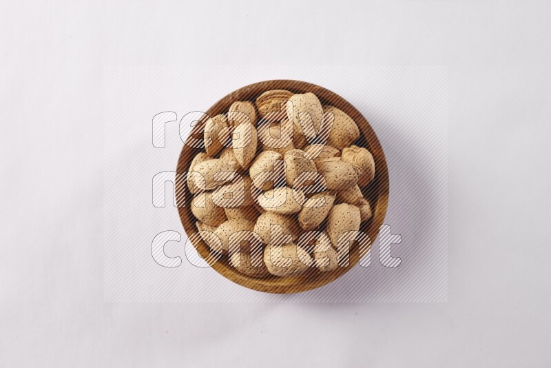 Almonds in a wooden bowl on white background