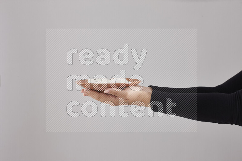 A woman in black abaya holding different pottery essentials in different positions