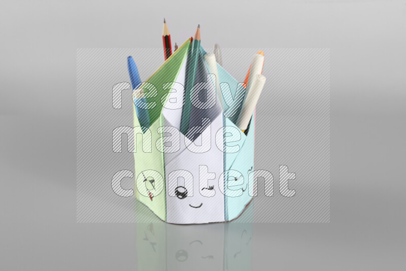 Origami pen holder on grey background