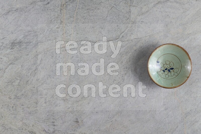 A decorative pottery plate on grey marble background