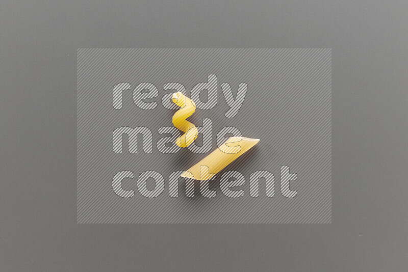 Twist pasta with other types of pasta on grey background