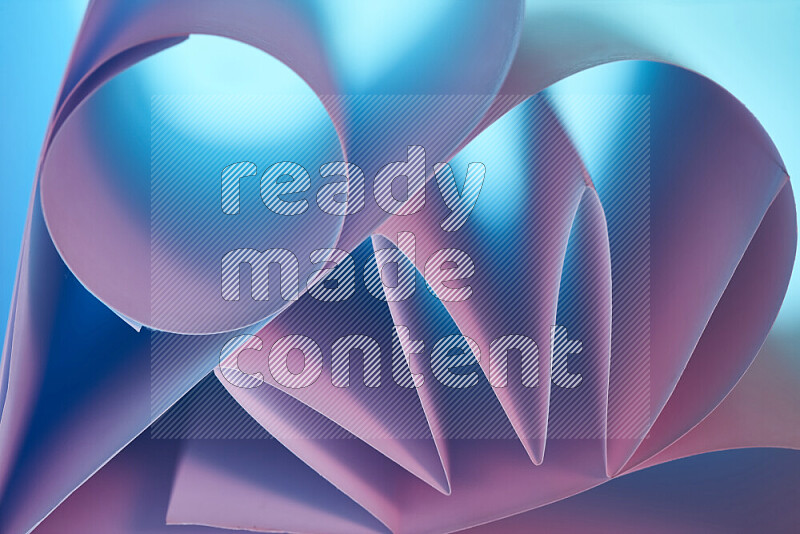 An artistic display of paper folds creating a harmonious blend of geometric shapes, highlighted by soft lighting in blue and pink tones