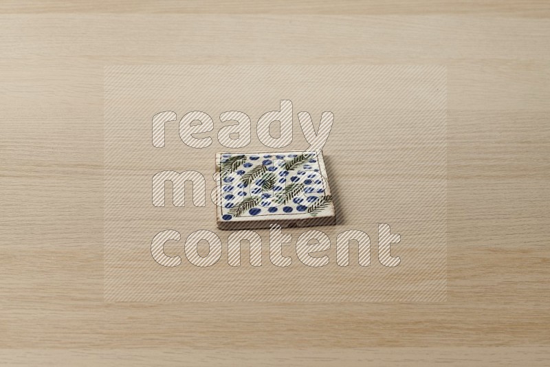 Pottery coaster\ tile on oak wooden flooring, 45 degrees