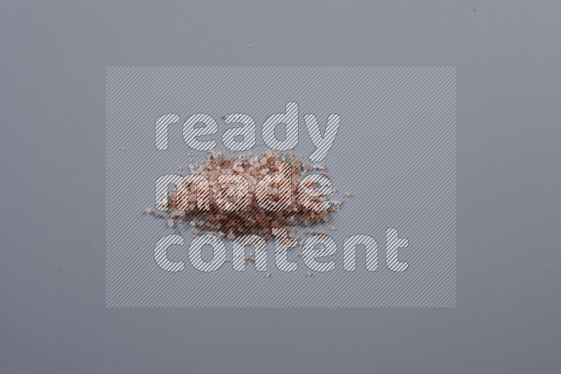 Bunches of table salt, coarse sea salt, fine himalayan salt and coarse himalayan salt on grey background