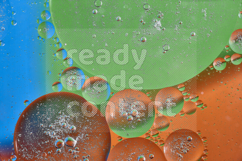 لقطات مقربة لفقاعات من الزيت على سطح الماء باللون البرتقالي والأخضر والأزرق