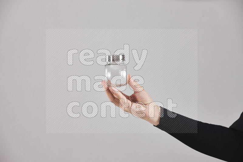 A woman in black abaya holding different glassware in different positions