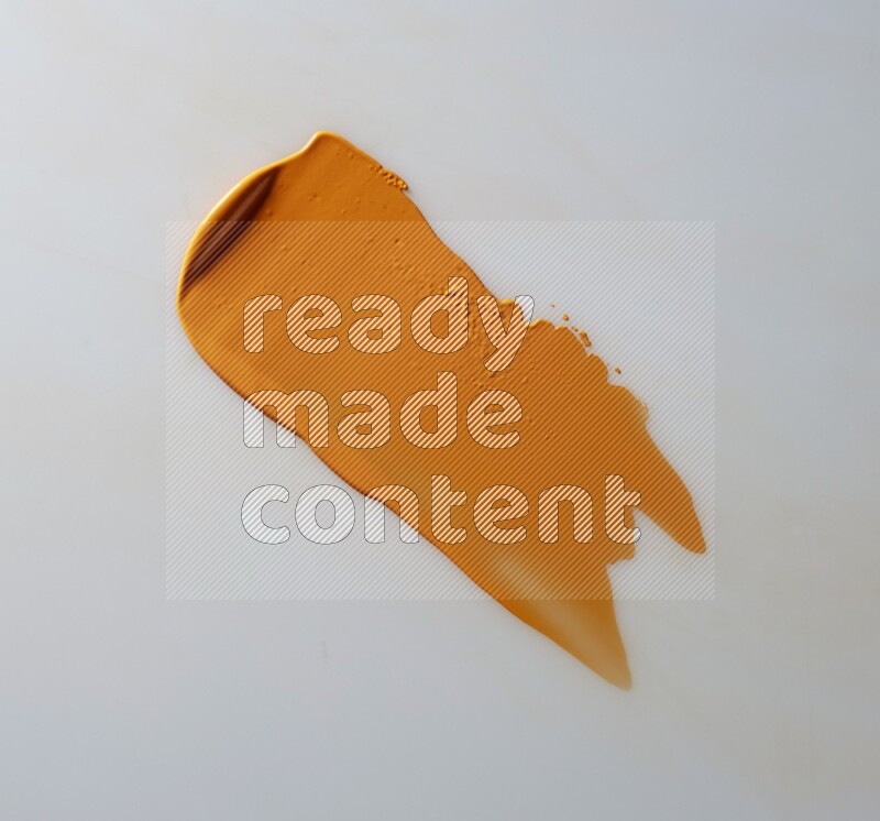 An orange straight painting knife stroke on white background