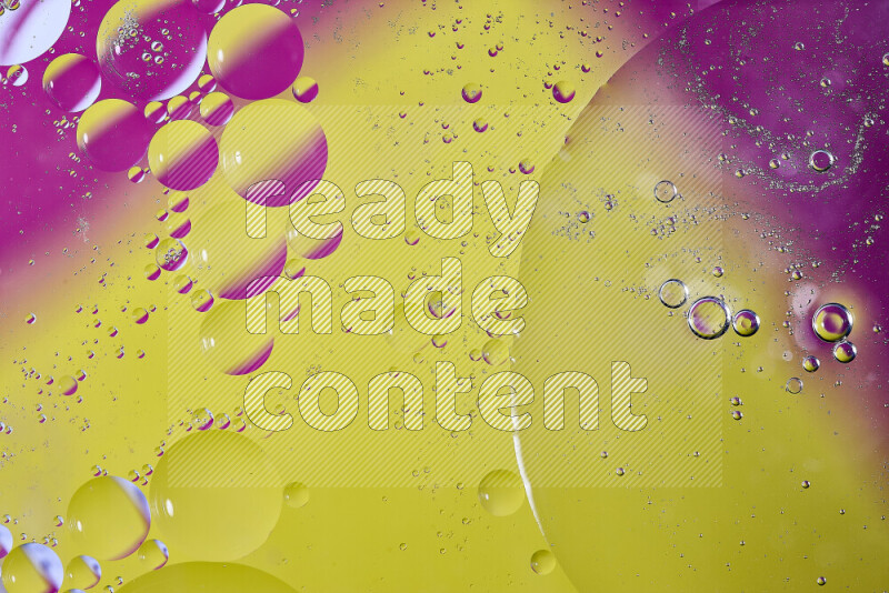 لقطات مقربة لفقاعات من الزيت على سطح الماء باللون الأصفر والوردي