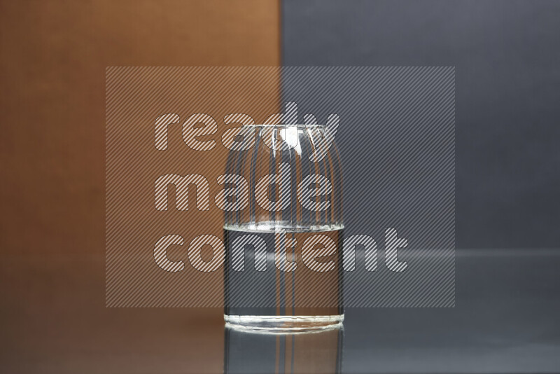 The image features a clear glassware filled with water, set against brown and dark blue background