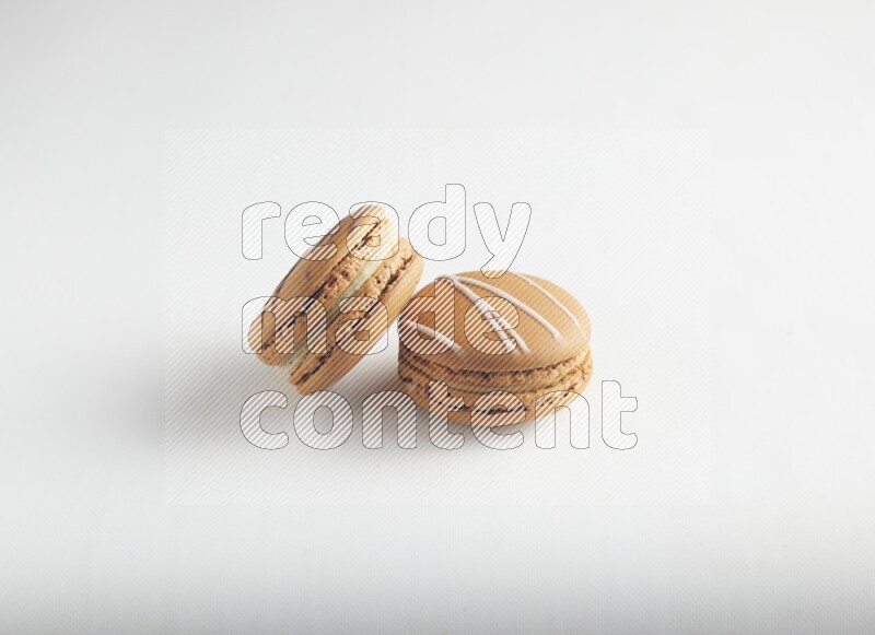 45º Shot of of two assorted Brown Irish Cream, and light brown  Almond Cream macarons on white background