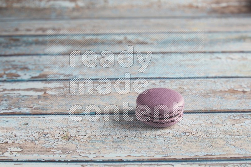 45º Shot of Purple Blueberry macaron on light blue wooden background