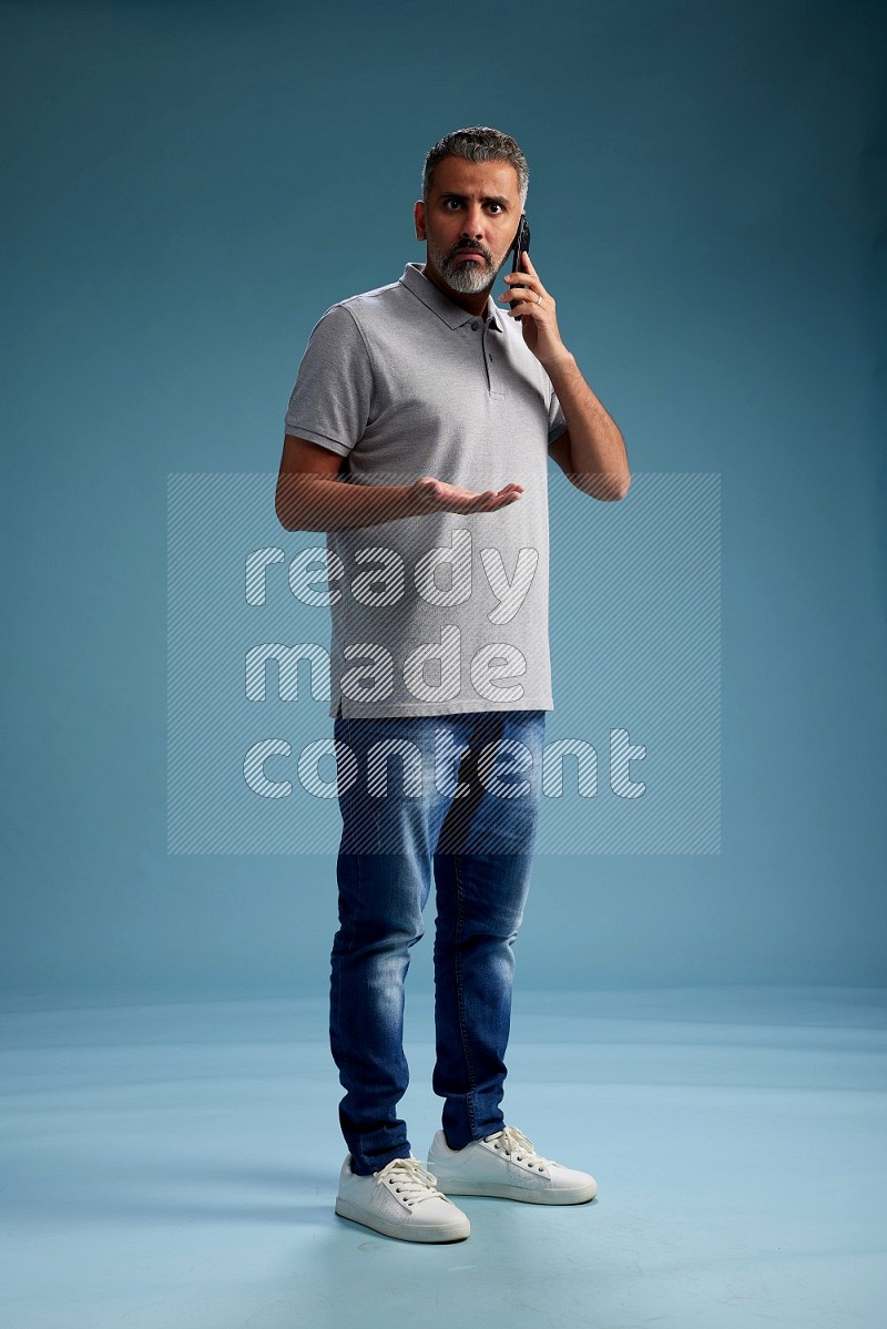 Man Standing talking on phone on blue background