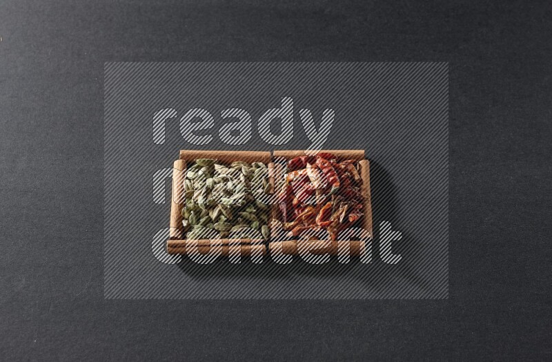 2 squares of cinnamon sticks full of chilis and cardamom on black flooring