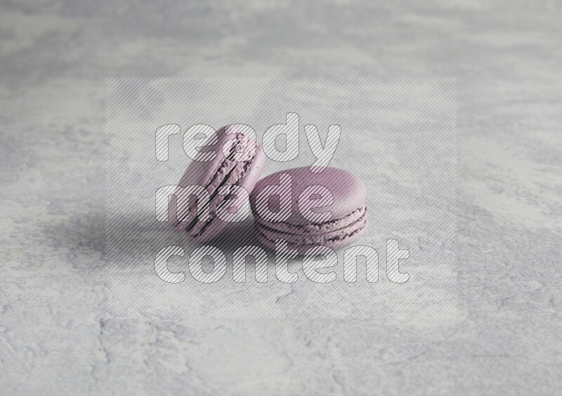 45º Shot of two Purple Blueberry macarons  on white  marble background