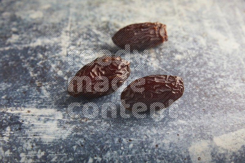 three madjoul dates on a rustic blue backround