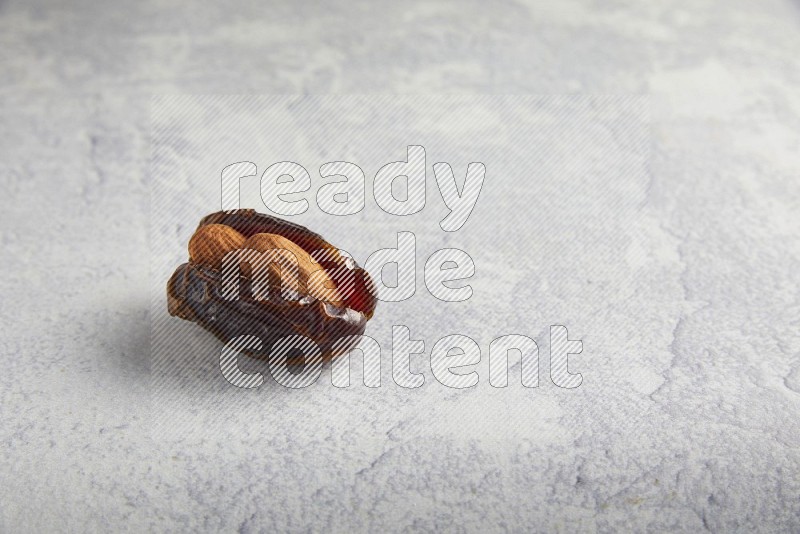 almond stuffed madjoul date on a light grey background