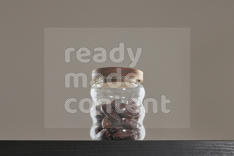 Dates in a glass jar on black background