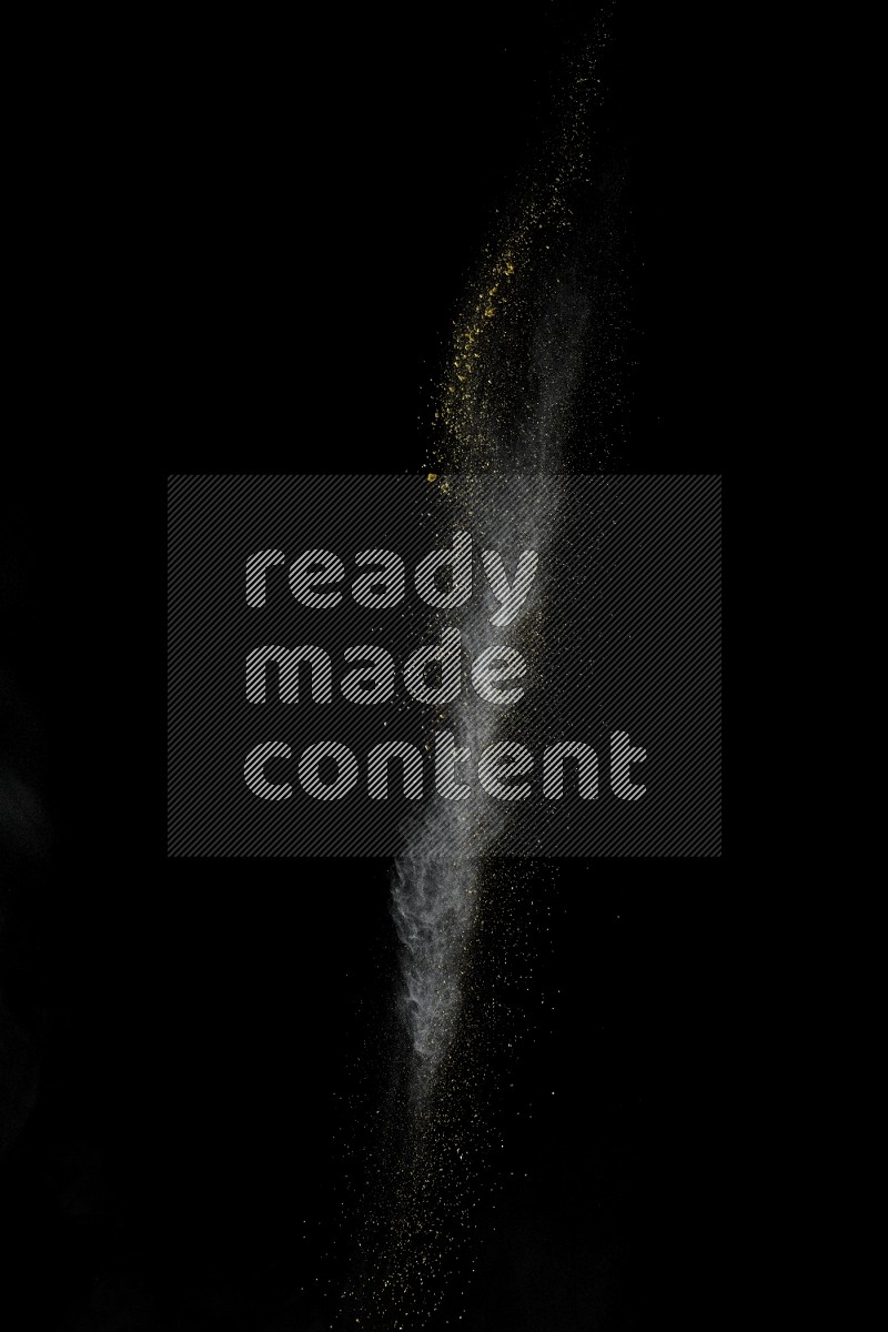 A side view of yellow powder explosion on black background