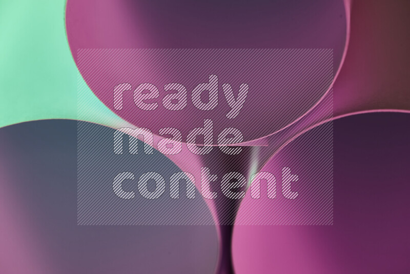 الصورة تعرض فن ورقي تجريدي بأشكال دائرية بدرجات متنوعة من اللون الأخضر والارجواني