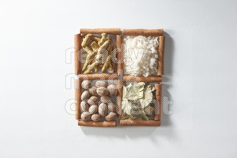 4 squares of cinnamon sticks full of salt, bay laurel, nutmeg, turmeric on white flooring