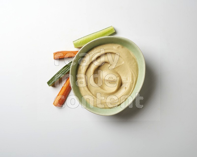 plain Hummus in a green plate on a white background