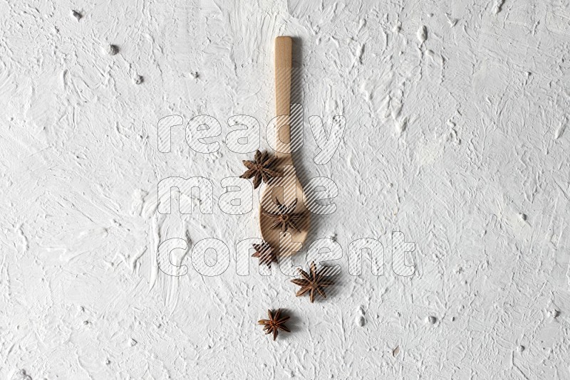 يانسون نجمي في ملعقة خشبية على خلفية بيضاء
