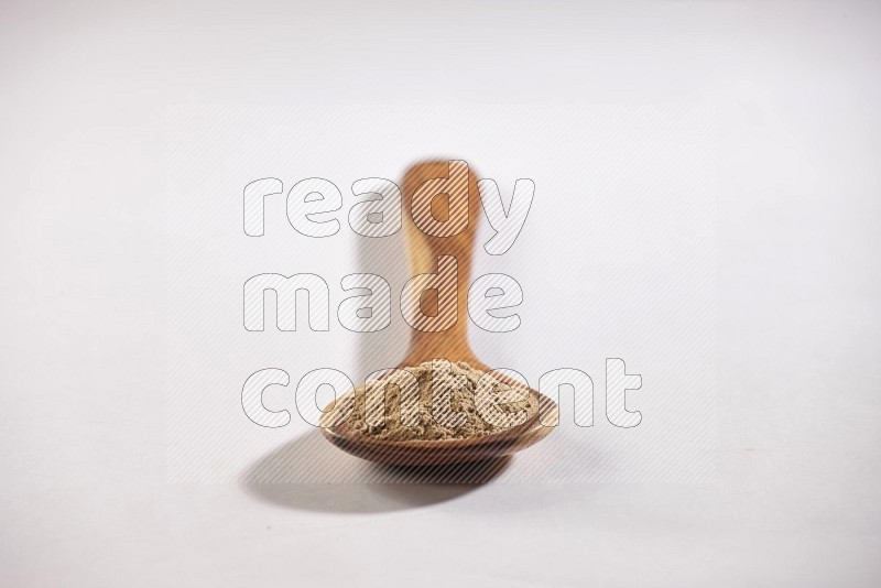 A wooden ladle full of garlic powder on a white flooring in different angles