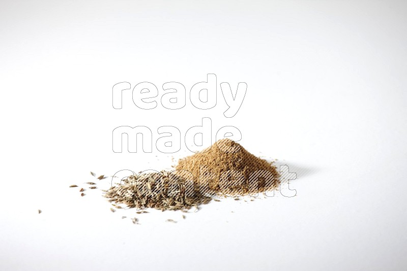 Cumin seeds and cumin powder on white flooring