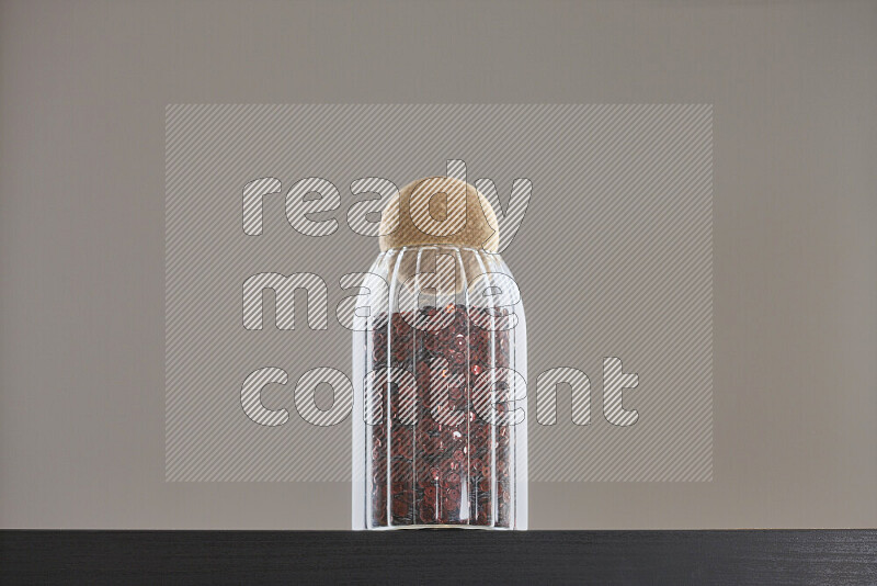 Sequins in a glass jar on black background