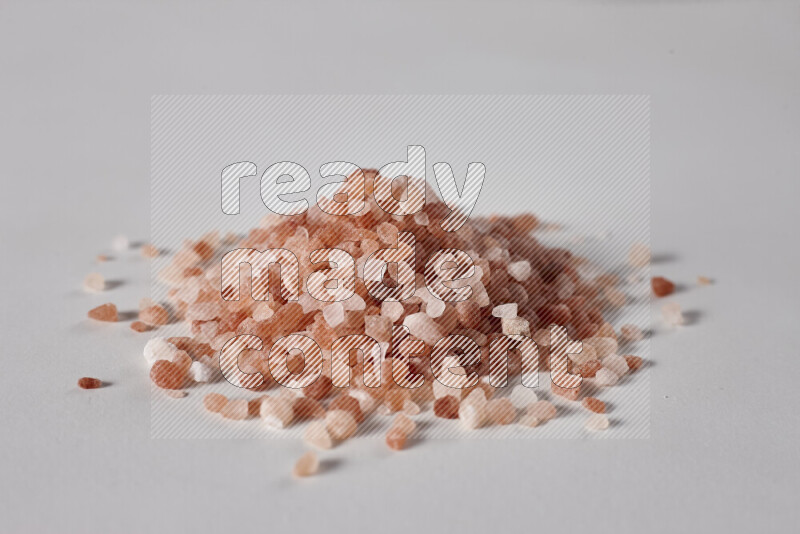 A bunch of coarse himalayan salt crystals on white background