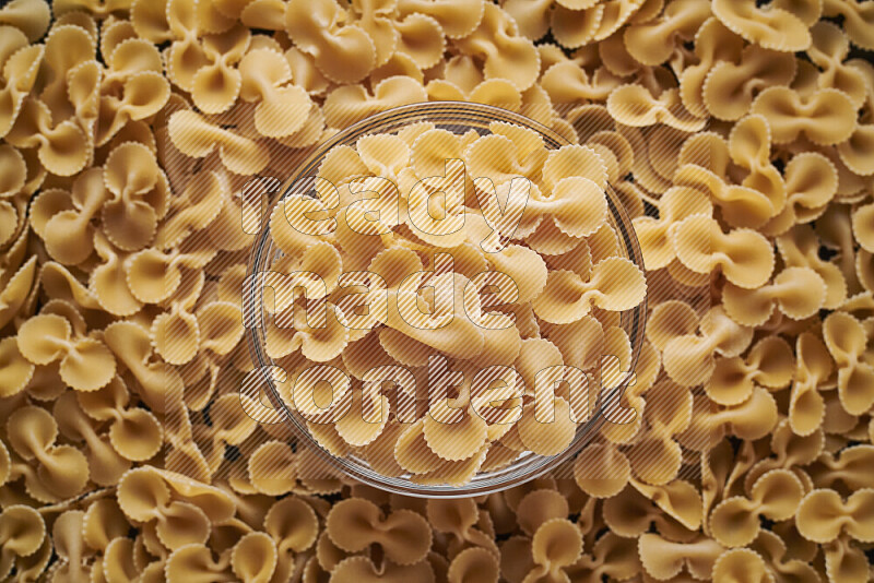 Fiocchi pasta in a glass bowl on black background