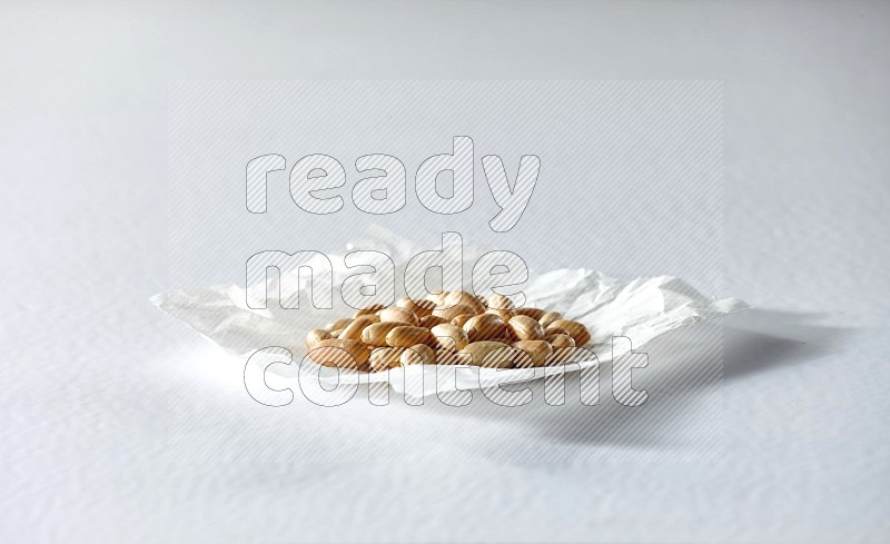 Peeled peanuts on a crumpled piece of paper on a white background in different angles