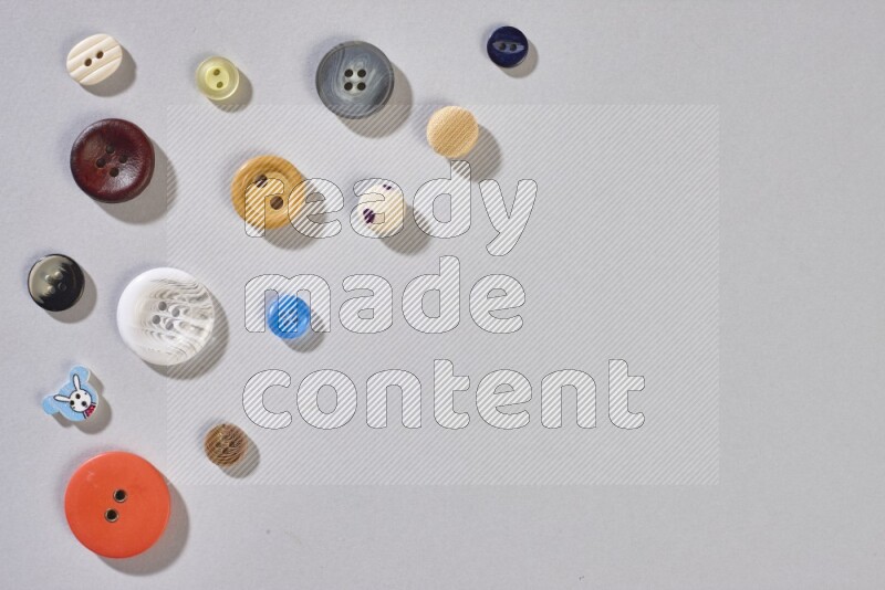 Mixed assorted buttons on grey background
